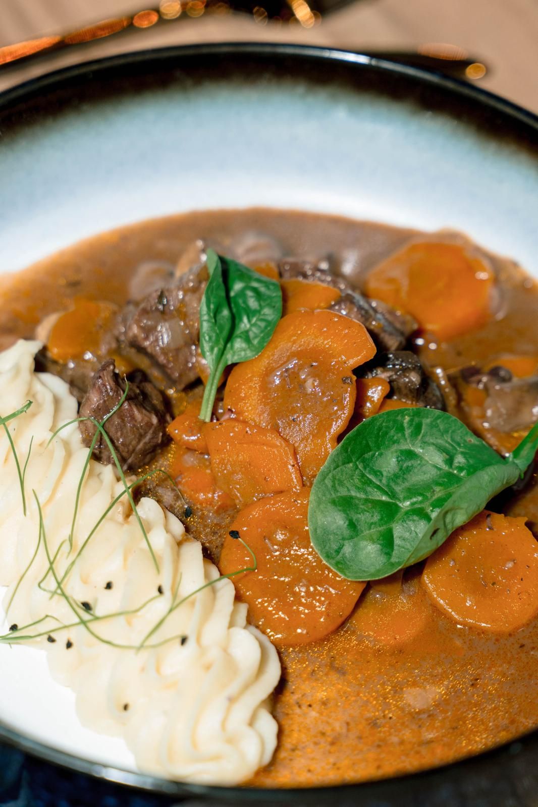 Plato de boeuf bourguignon con zanahoria, espinaca y puré