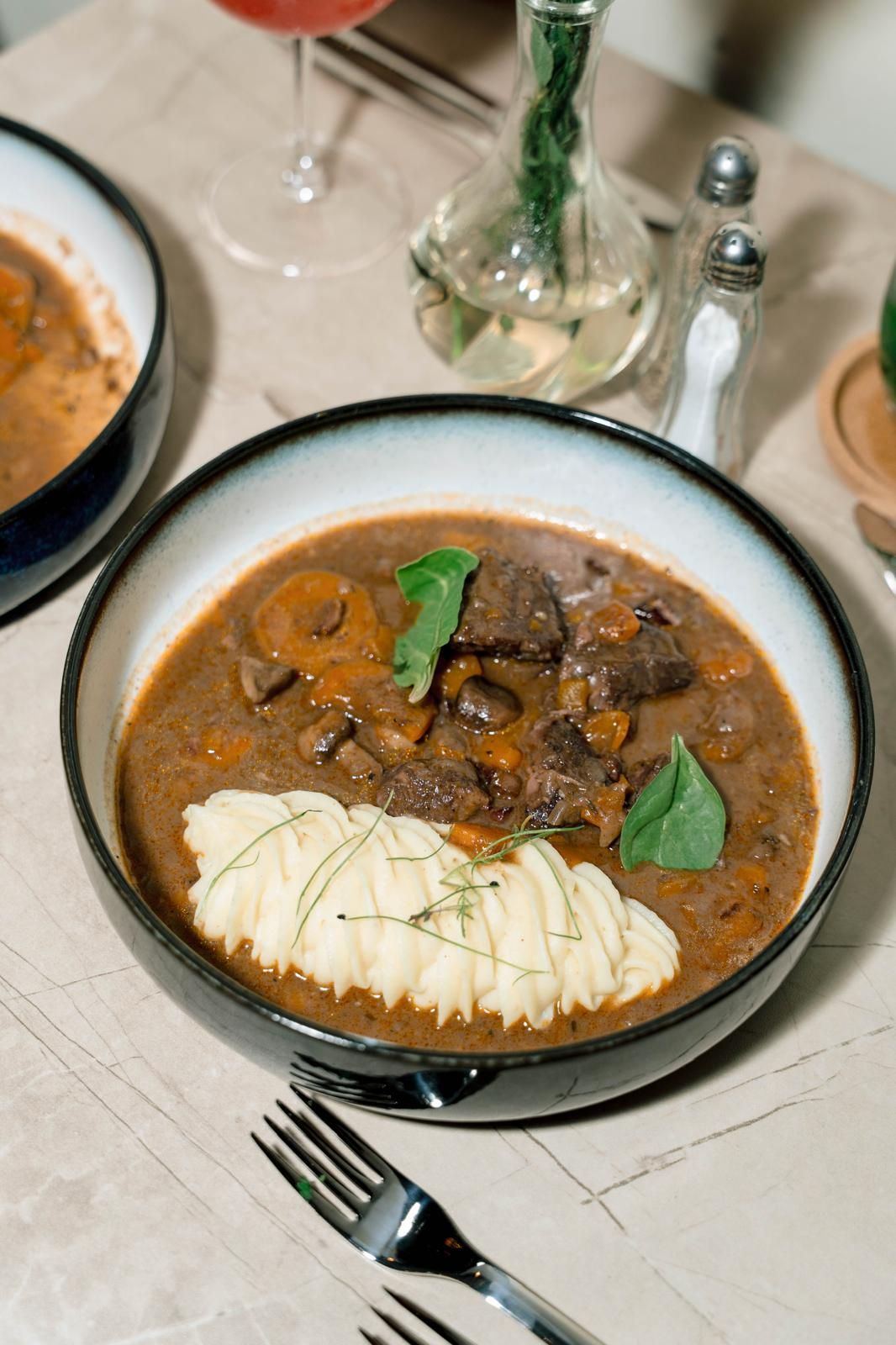 Boeuf bourguignon con puré de papa, servido en la mesa